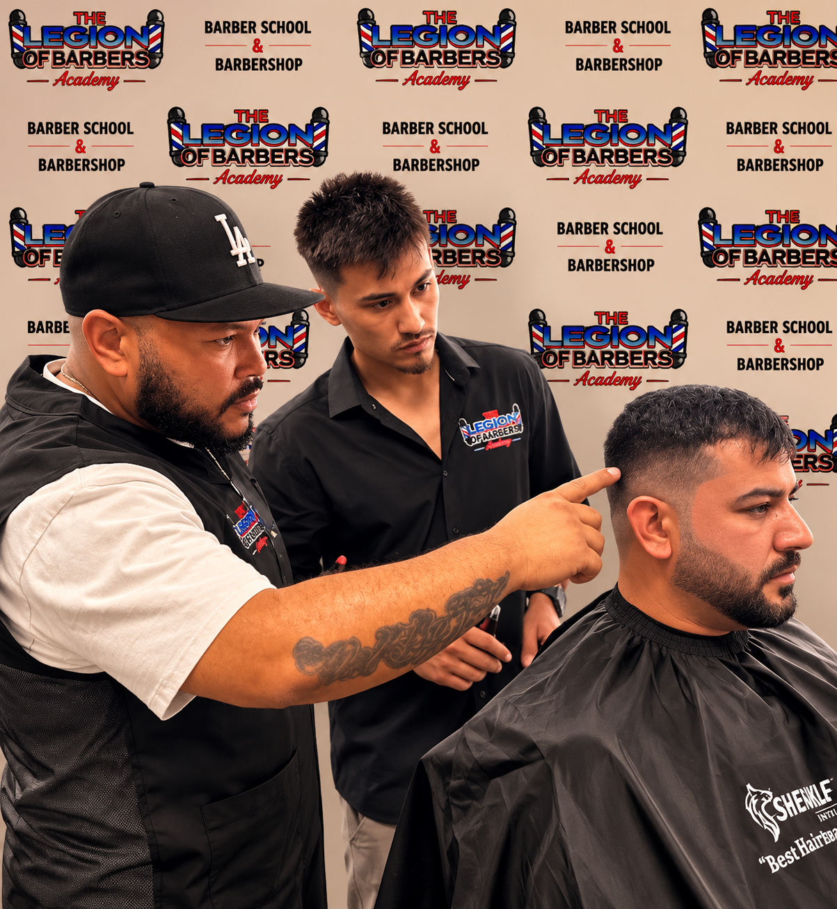 Instructor teaching a student barber technique on a live client
